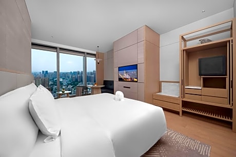Deluxe King Room -City View  1 welcome fruit on the first day, 1 voucher for daily laundry cost of 100 RMB (non-cumulative), 1 voucher for 300 RMB for Health Center, 1 voucher for playing 1000㎡children's playground, 1 single cocktail