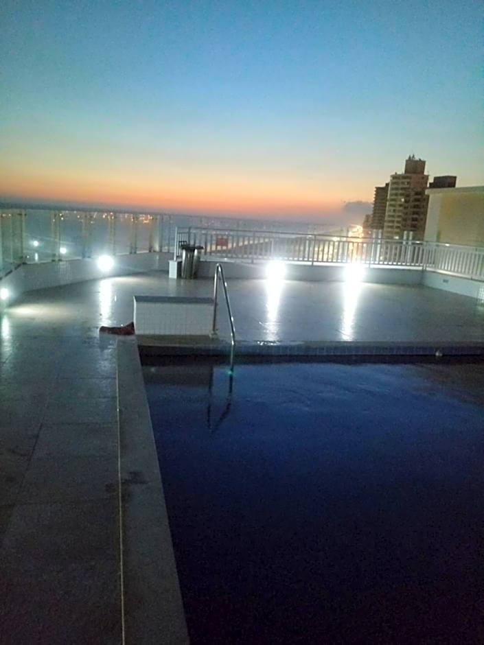Prédio com piscina na cobertura frente ao mar, apartamento para até 6 pessoas e 3 crianças até 8 anos, churrasqueira na sacada, Wi-Fi grátis, NÃO oferecemos roupas de cama e banho, 1 vaga de garagem, na Praia Grande-Vila Mirim